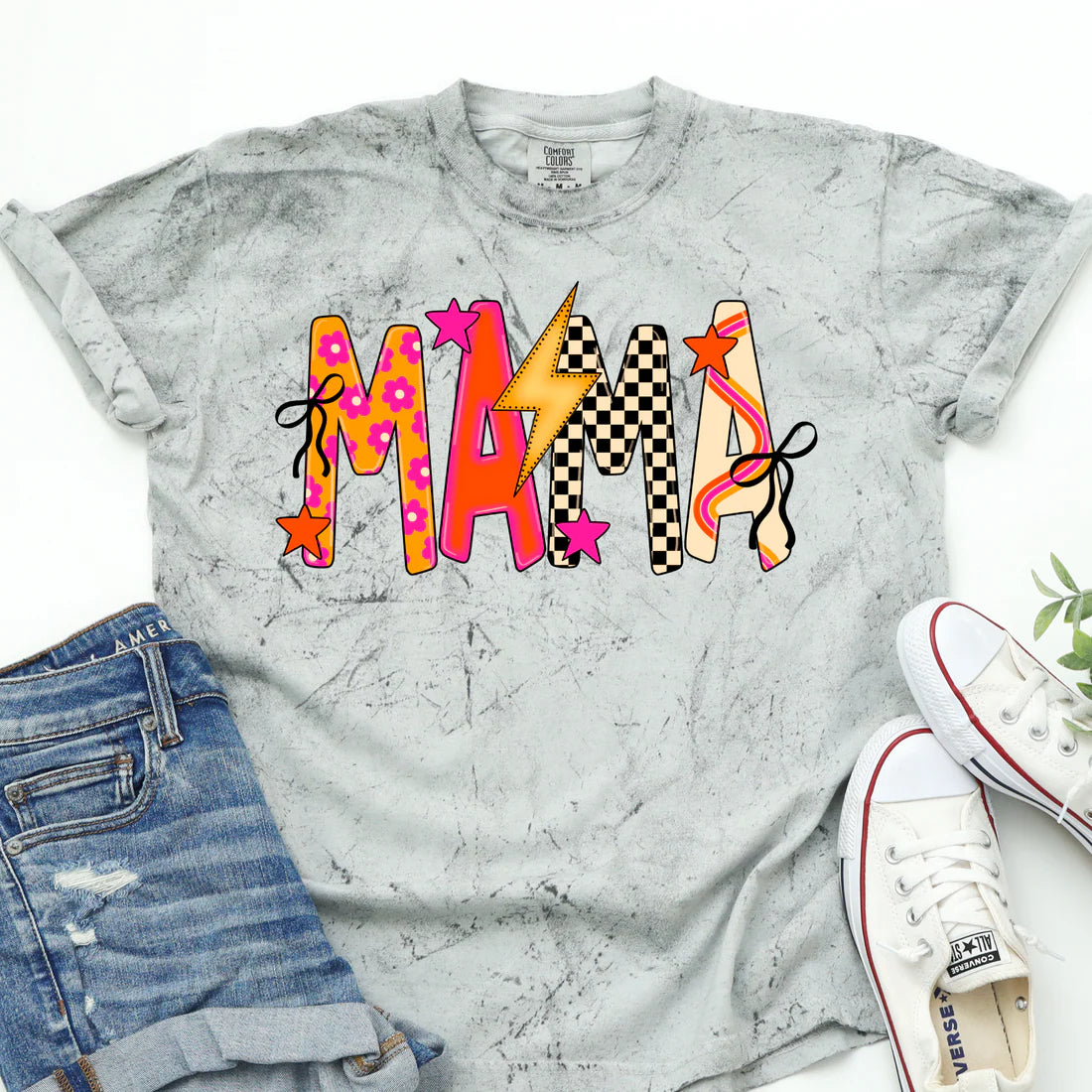 Gray and white marbled t-shirt with colorful 'MAMA' design, paired with denim shorts and white sneakers on a white background.