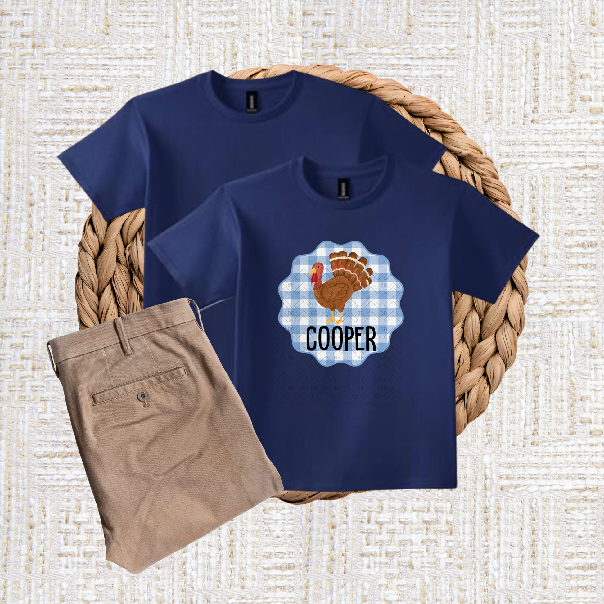 Navy blue t-shirt with a turkey graphic and 'Cooper' text, paired with beige pants on a textured surface.