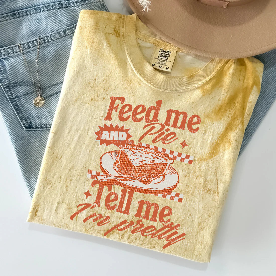 T-shirt with 'Feed me and pie, tell me I'm pretty' text and graphic on a light background