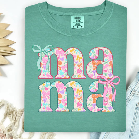 Green t-shirt with floral 'ma ma' text and ribbons on a white background