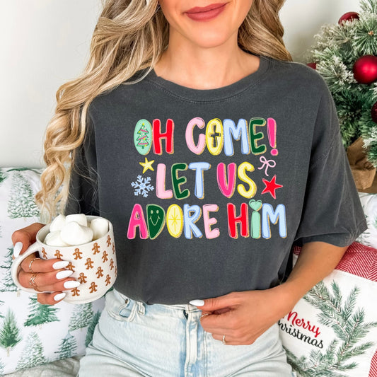 Person wearing a dark gray t-shirt with colorful Christmas-themed text, holding a mug with a gingerbread design.
