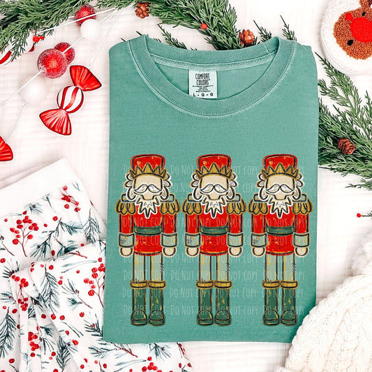 Teal t-shirt with nutcracker design on a festive background