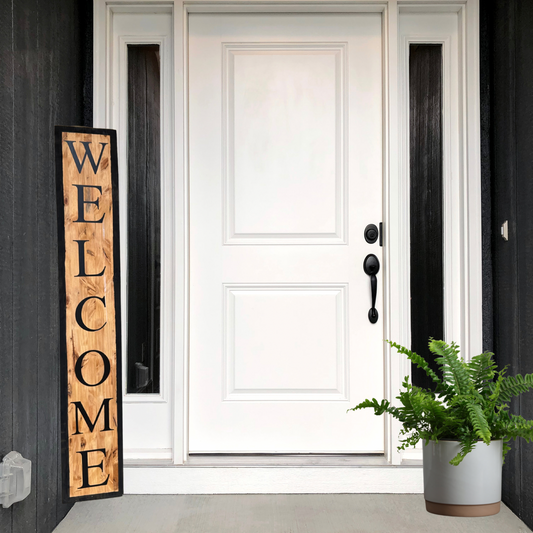 White front door with wood welcome sign and outdoor fern for decoration, showcasing sign styling.