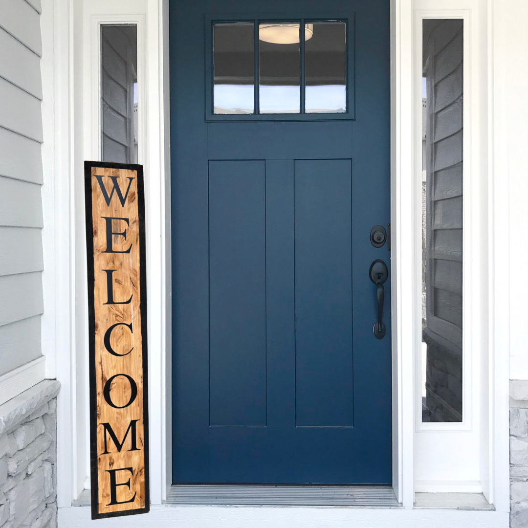 Navy blue front door with wood welcome sign, showcasing sign styling