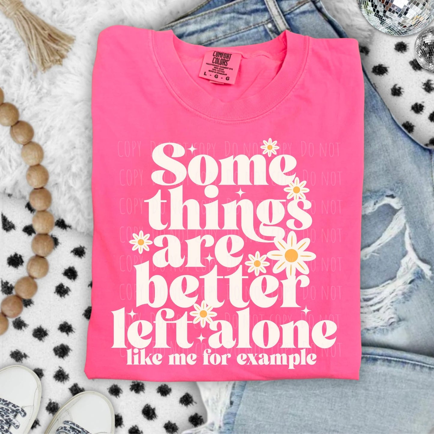 Pink t-shirt with text and flowers on a textured surface